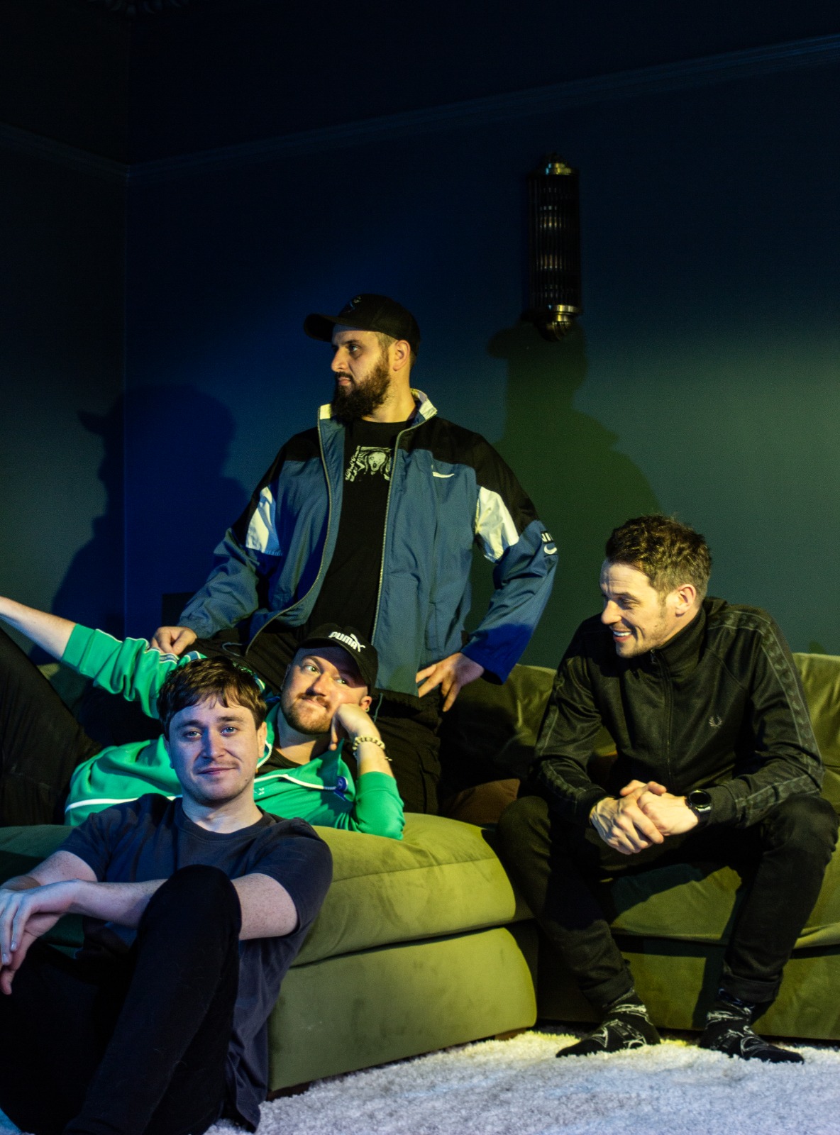32tens ad3 32tens band sat on a couch in a dark room